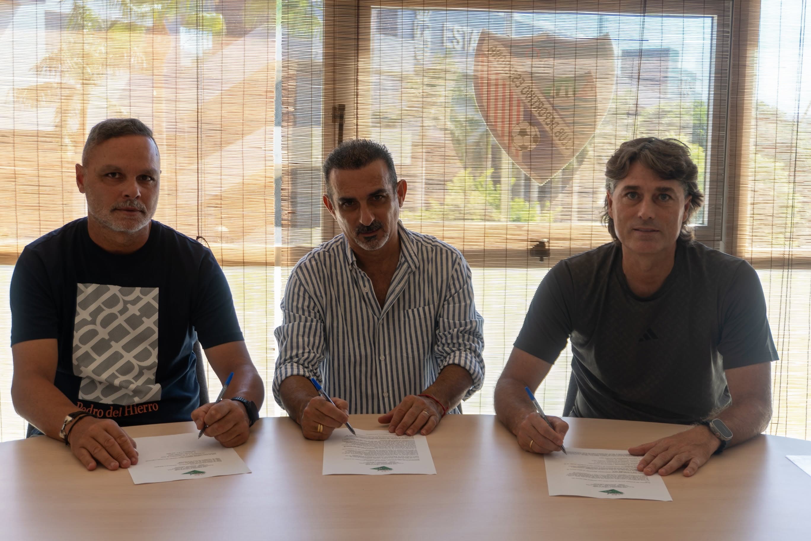 Antonio Sánchez, Manolo Cáceres y Julen Guerrero firmando el acuerdo