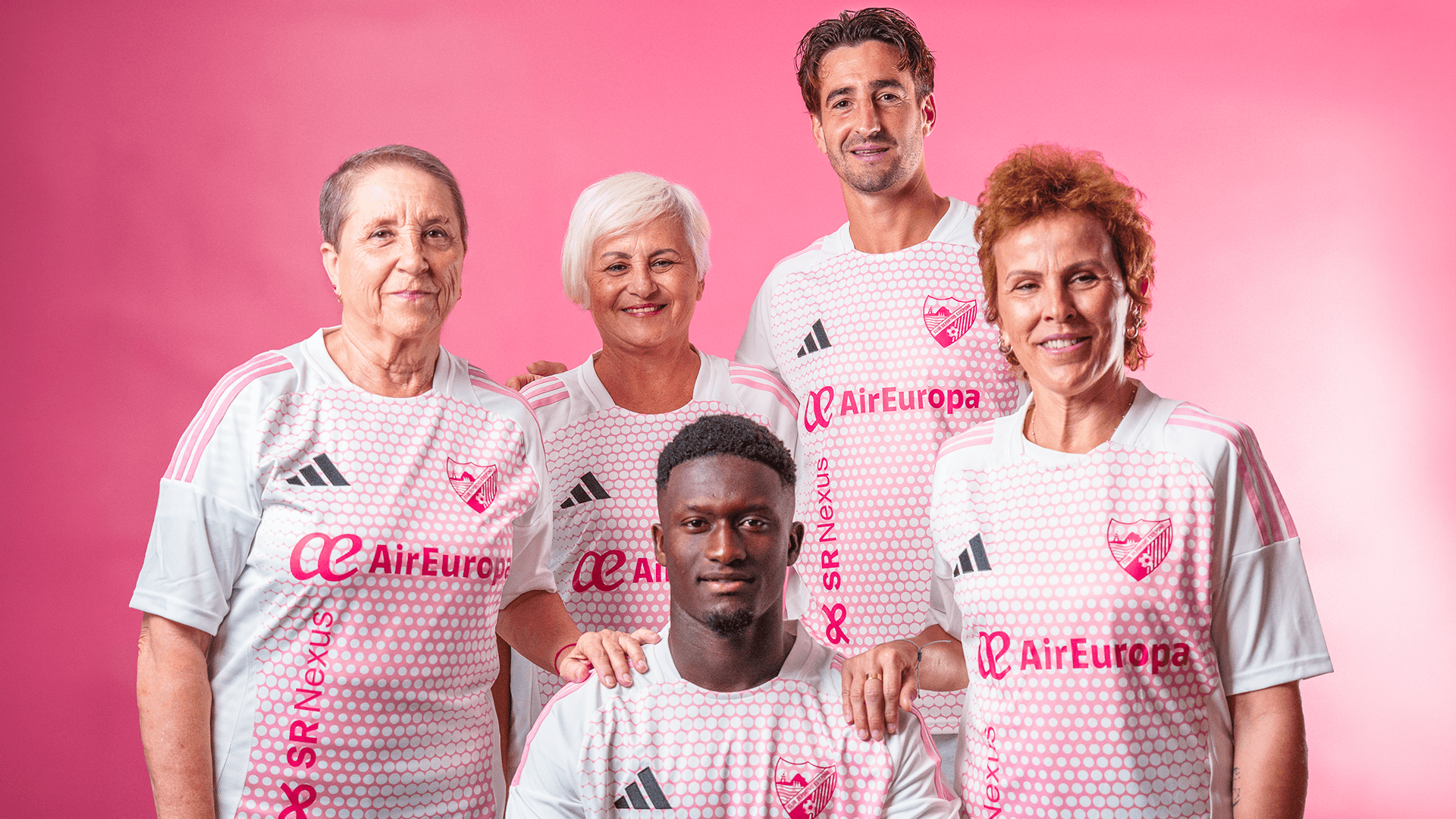 Jugadores del CD Estepona junto a tres mujeres de la AECC de Estepona durante la presentación de la camiseta solidaria contra el cáncer de mama